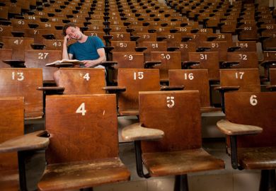Bored student asleep in empty lecture hall