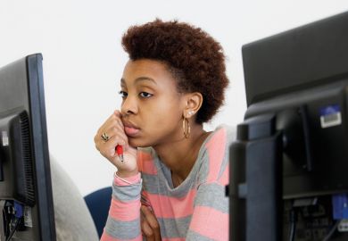 Bored young woman looking at computer screen
