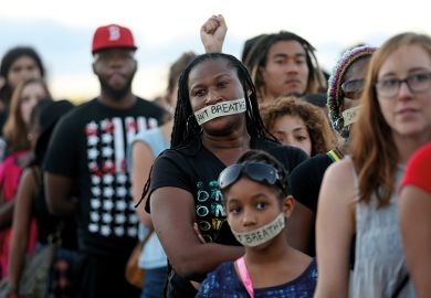 Demonstrators stand with tape reading: “ I can’t breathe” to protest police abuse on December 7, 2014 in Miami, Florida.