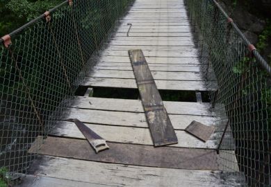 A wooden bridge with missing planks A wooden bridge with missing planks, symbolising precarity