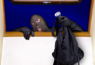 A masked person climbing through a window