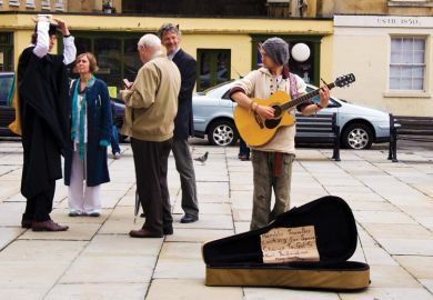Busker watching a graduating student and his family