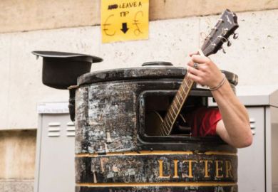 Busker playing guitar in litter bin