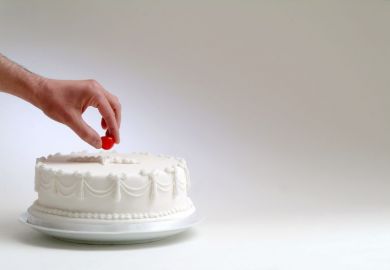 Cake with hand taking cherry on top