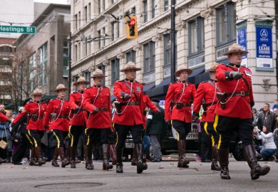 Vancouver, BC, Canada – November 11, 2016: RCMP officers, dressed in ceremonial red serge, march through downtown Vancouver for Remembrance Day.