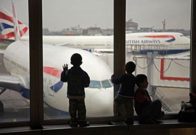 Children looking at British Airways planes out of an airport window. To illustrate the UK banning dependants. 