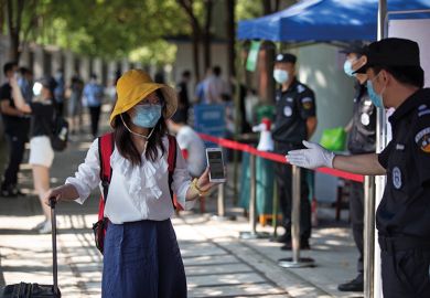 Student in mask shows mobile phone to health check in Wuhan, China Student in mask shows mobile phone to health check in Wuhan, China