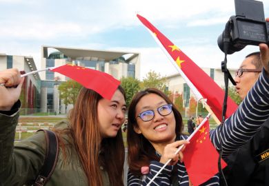 Two women take a selfie with Chinese flags
