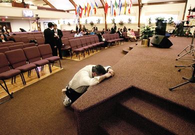 man prays in church