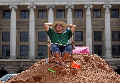 A person takes a break on a temporary city centre beach, Nottingham, UK. To illustrate a four-day week.