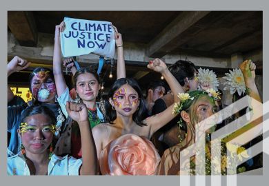 Youth advocates raise their fists after a fashion show protest in support for the Fridays for Future movement in fighting for climate justice at the University of the Philippines in Quezon City, suburban Manila on 23 September, 2022.