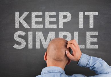 Confused man looking at 'Keep it simple' sign Confused man looking at 'Keep it simple' sign