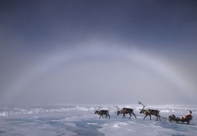 Santa pulled by reindeer under an ice bow, ice crystals creating the arctic equivalent of a rainbow