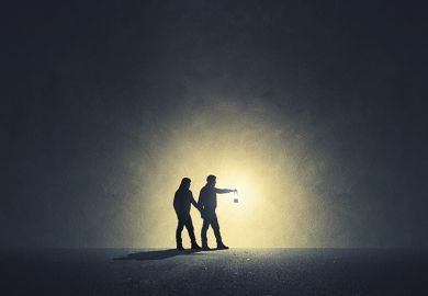 Two people walk in darkness with lamp illuminating their path