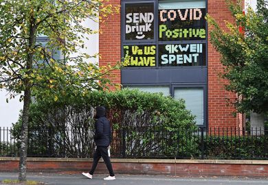 A man walks past messages pasted inside the windows of student accommodation at Manchester Metropolitan University A man walks past messages pasted inside the windows of student accommodation at Manchester Metropolitan University