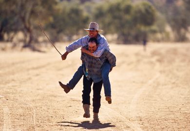 Cowboy carries friend on his back