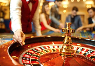 Croupier holds a roulette ball in a casino