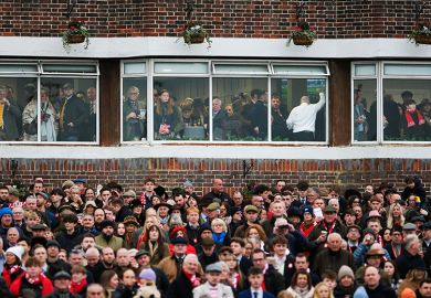 A busy crowd, with some in a hospitality area, at the races at Kempton Park in Sunbury, England. To illustrate a two tier workforce.