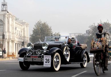 Classic car rally in New Delhi next to person on push bike to illustrate Nepotism warning as Delhi fills thousands of academic posts