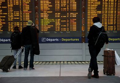 Passengers check departures board