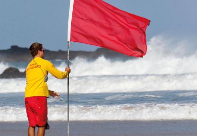 Man holding red flag on beach Man holding red flag on beach