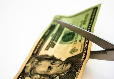 Scissors cut a $20 bill