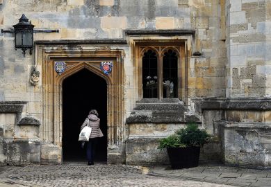 Woman walking through archway at university 