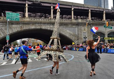 A runner carries a model of the Eiffel Tower during the New York City Marathon in New York, USA. To illustrate that European governments and institutions are launching schemes to attract US talent. A runner carries a model of the Eiffel Tower during the New York City Marathon in New York, USA. To illustrate that European governments and institutions are launching schemes to attract US talent.