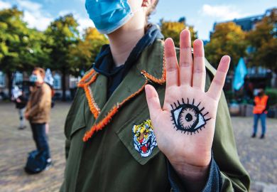 XR activists standing up with eyes painted on placards in front of the House of the Parliament where the New Extinction Rebellion campaign has started in The Hague, Netherlands on September 1, 2020