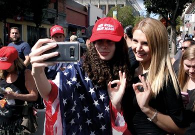 Women draped in stars and stripes take selfie Women draped in stars and stripes take selfie