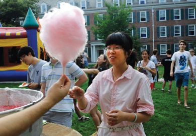 Female student buying cotton candy, Yale Summer School