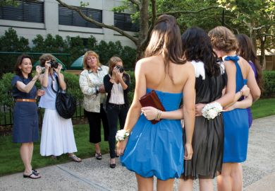 Female students being photographed by their mothers and sister before senior prom Female students being photographed by their mothers and sister before senior prom