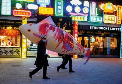 Security guards wearing face masks carry a giant balloon in the shape of a fish in Shanghai