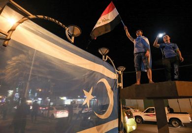 Iraqis wave their national flag and the flag of the Iraqi Turkmen as they celebrate in the city of Kirkuk in October 2017