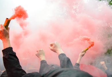 Dutch football fans clench fists and hold orange flares Dutch football fans clench fists and hold orange flares