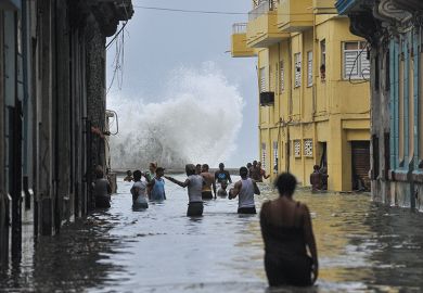 Cubans wade through a flooded street in Havana after Hurricane Irma swept through the country in 2017
