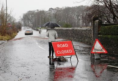 A sign before a flooded road says 'Road closed'