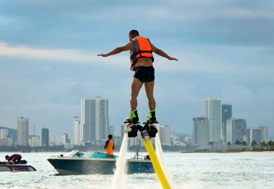 Man on a flyboard (aerial machine for personal watercraft) in Vietnam. To illustrate Vietnam’s new wave of ambitious universities. Man on a flyboard (aerial machine for personal watercraft) in Vietnam. To illustrate Vietnam’s new wave of ambitious universities.