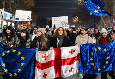 Georgia pro-Europe demonstrators hold Georgian and European flags during a protest against the Government's postponement of European Union accession talks until 2028, outside the Parliament in central Tbilisi, Georgia, on December 11, 2024
