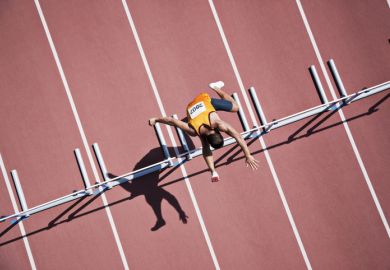 Runner jumping hurdles on track