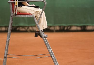 Female referee on a clay tennis court 