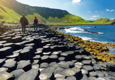 Two tourists walking at Giants Causeway Two tourists walking at Giants Causeway