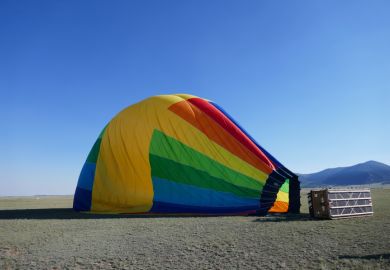  Deflated rainbow colored hot air balloon laying on side