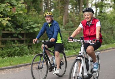 Senior couple wearing sports clothing and cycling helmets on a summers day