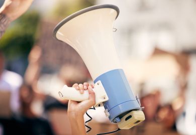 a protester holding a megaphone during a rally a protester holding a megaphone during a rally
