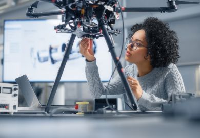A black female engineer working on what appears to be a drone 