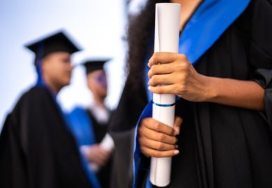 Close-up of a young woman holding a diploma on graduation 