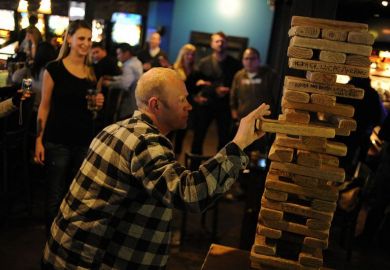 Troy Benson eases a block out an oversized Jenga game