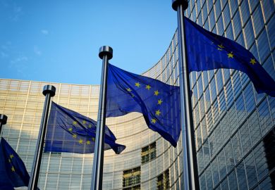 Several EU flags in front of the European Commission building in Brussels
