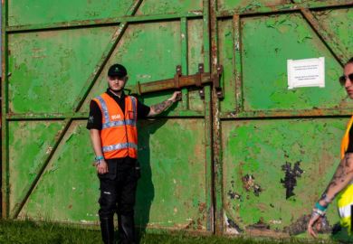A security guard waits to open the gate at Glastonbury Festival A security guard waits to open the gate at Glastonbury Festival